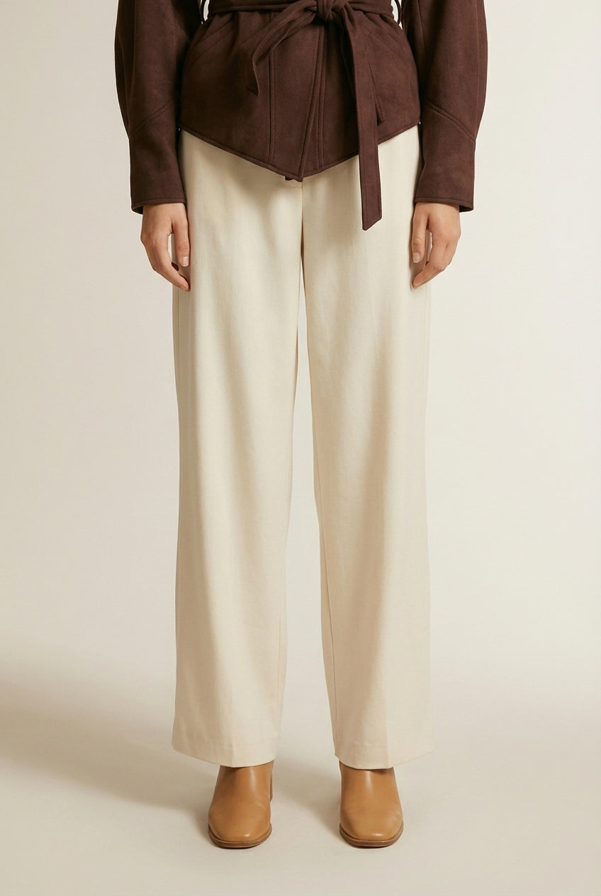 Close-up of the model's lower body wearing ELINE | Veste femme à épaules plissées et ceinture nouée